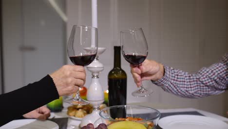 cerca de las copas de vino rojo sonando durante la cena romántica. feliz alegre pareja de ancianos mayores