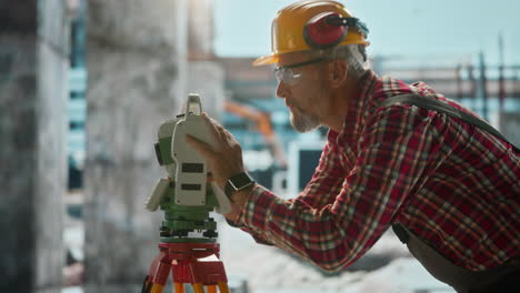 professional surveyor working with total station at construction site