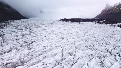 Ein-Flug-über-Einem-Gletscher-In-Island-Offenbart-Faszinierende-Eismuster,-Während-Die-Kamera-In-Einem-Annäherungsflug-Gleitet-Und-Aufsteigt