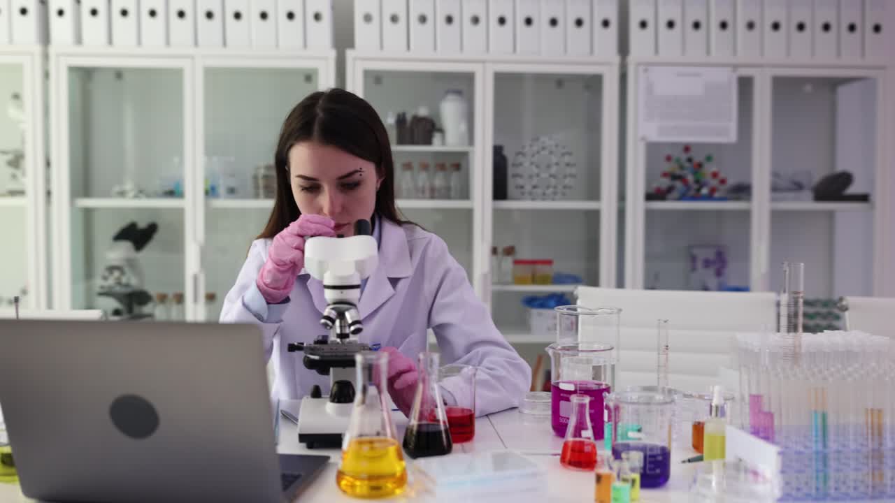 Científico trabajando con microscopio en laboratorio.
