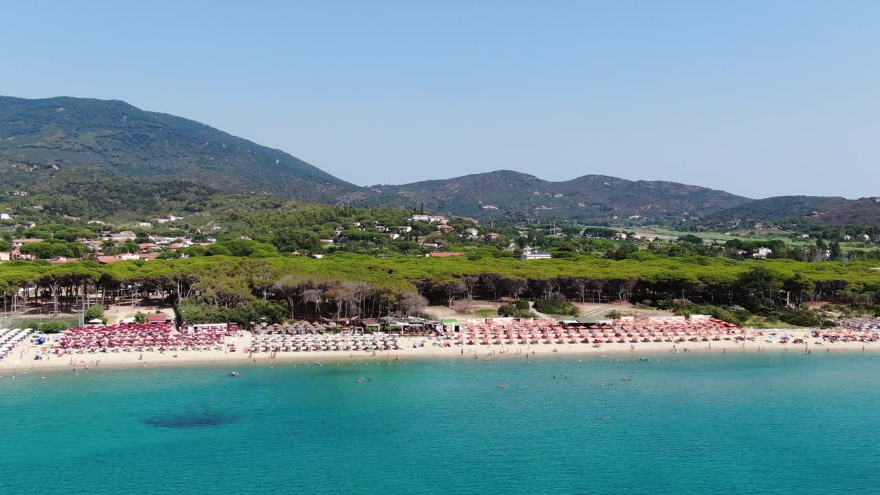 Swimmers exploring clear waters while boats drift gently along Elba’s coastline