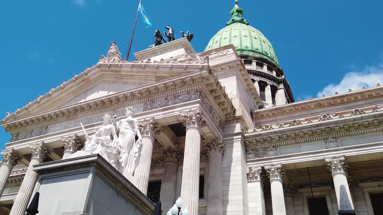 Low angle view Argentine congress, National flag emblematic public building, birds fly by sunrise blue skyline
