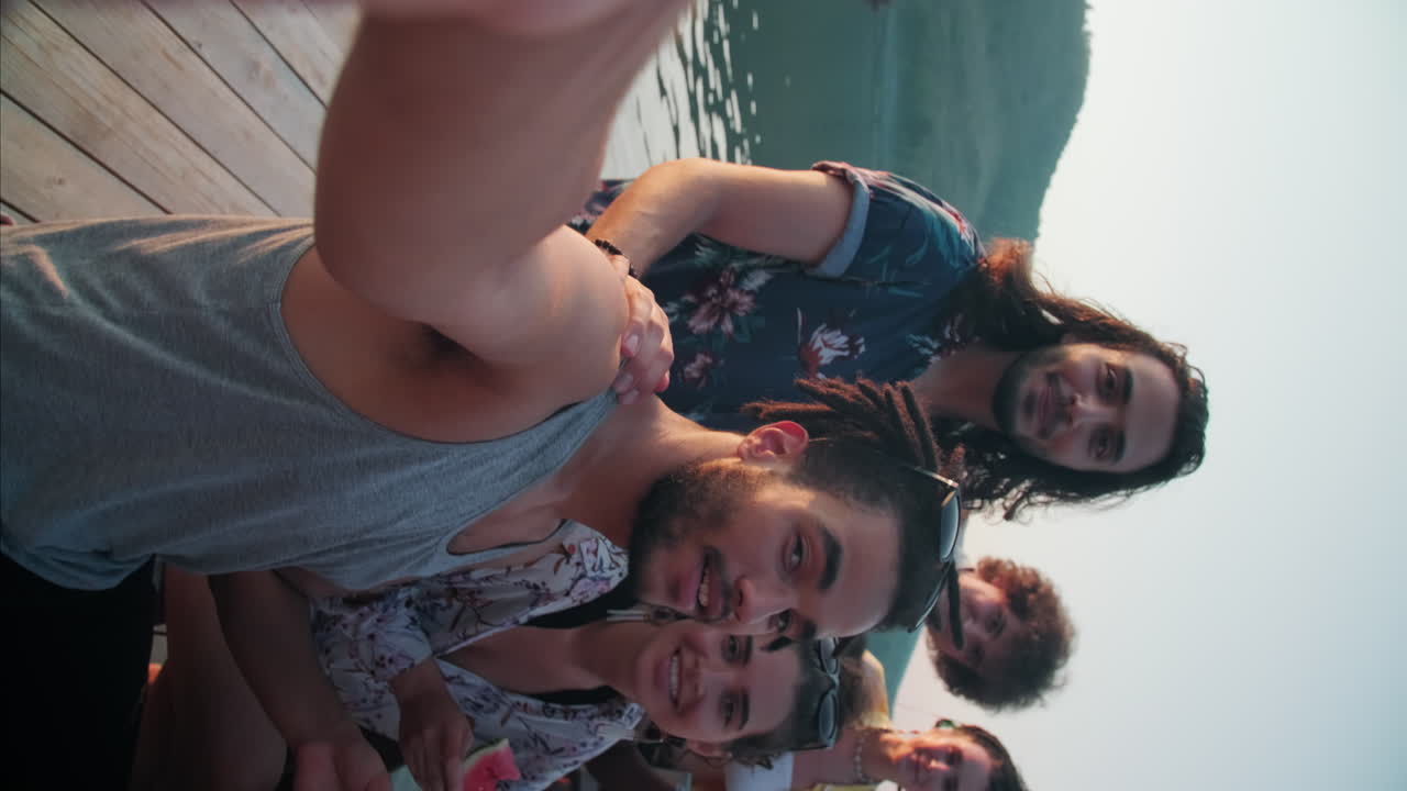 Amici allegri e di diverse etnie che posano per un selfie a una festa sul lago