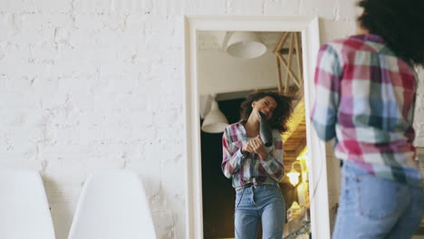 woman styling hair in front of mirror