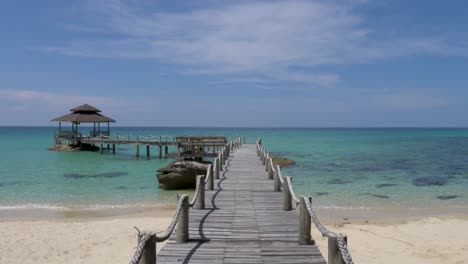 wide shot pov walking on wooden footbridge that leads to the sea