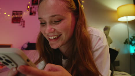 young woman using phone in bed at night