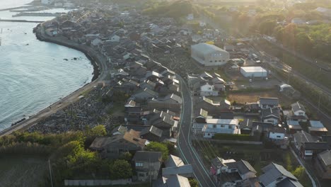 sunrise over sea of japan and small mikuriya town, tottori, aerial tilt shot