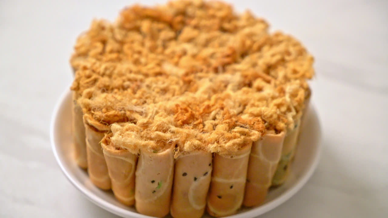 Rollo de coco crujiente con carne de cerdo desmenuzada seca en la placa