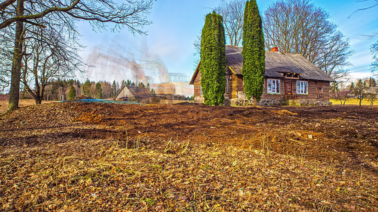 오래된 목조 시골 농가 근처에서 파는 무거운 굴착기, 융합 시간 경과