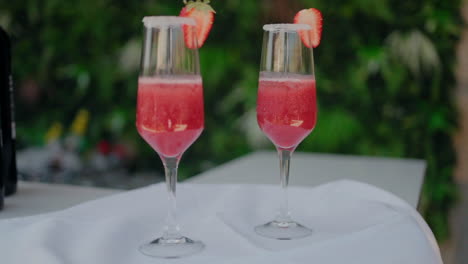 dos elegantes cócteles de fresa en vasos de champaña con bordes de azúcar, perfectos para celebraciones