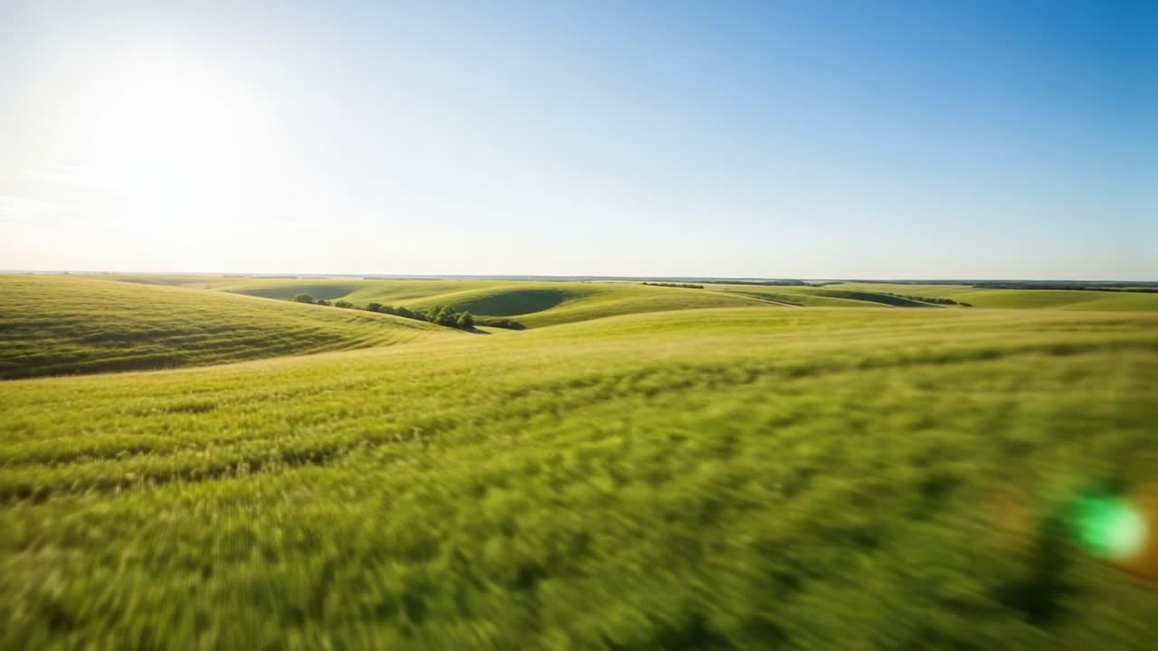 Expansive Green Landscape Under Clear Blue Sky, Capturing the Beauty of Nature's Rolling Hills and Vibrant Fields in a Serene, Breathtaking Scenic View
