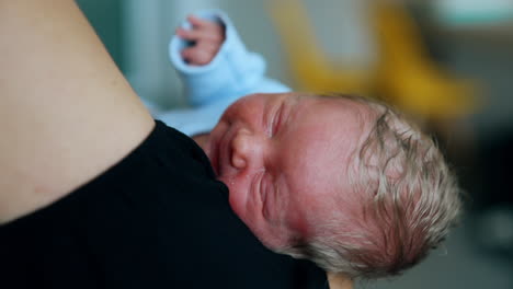 little baby lying in mom's hands. newborn falling asleep in mother's arms. close up.