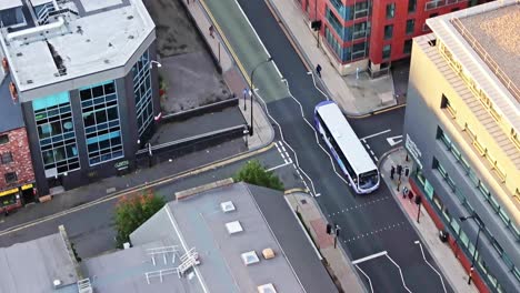 drone shot following bus driving through city centre in england