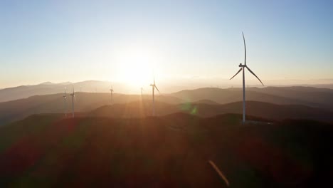 sunflares and rays on drone flight around wind farm with rotating wind turbines