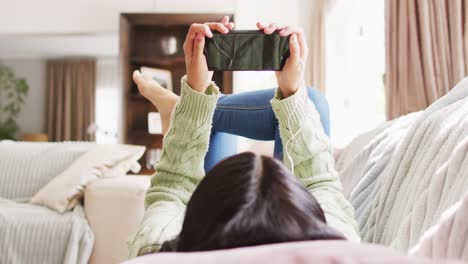 video of smiling biracial woman with dark hair using smartphone