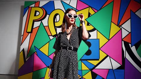 stylish woman in polka dot dress against a colorful pop art background