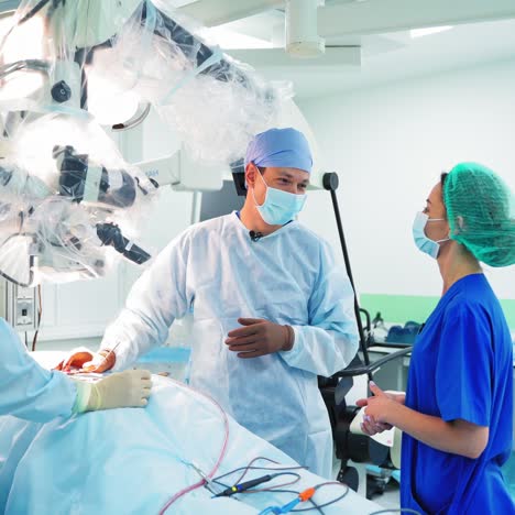 medical specialists in the hospital. conversation between doctors in the surgical room. surgeon and female doctor in medical uniform have a talk during surgery.