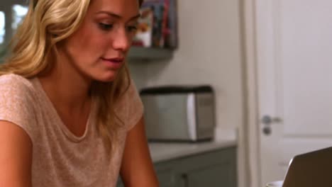 Pretty-woman-using-laptop-in-the-kitchen