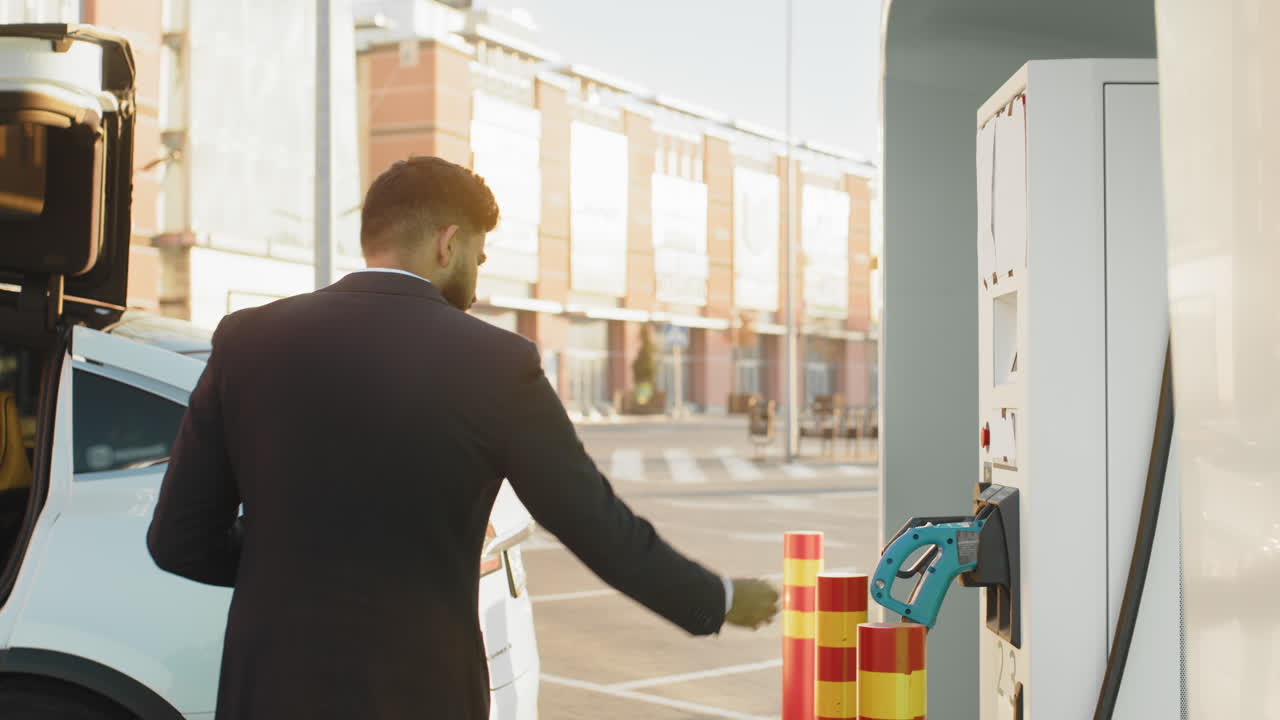 hombre de negocios cargando un vehículo eléctrico en una estación de carga