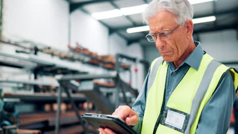 senior worker using tablet in warehouse