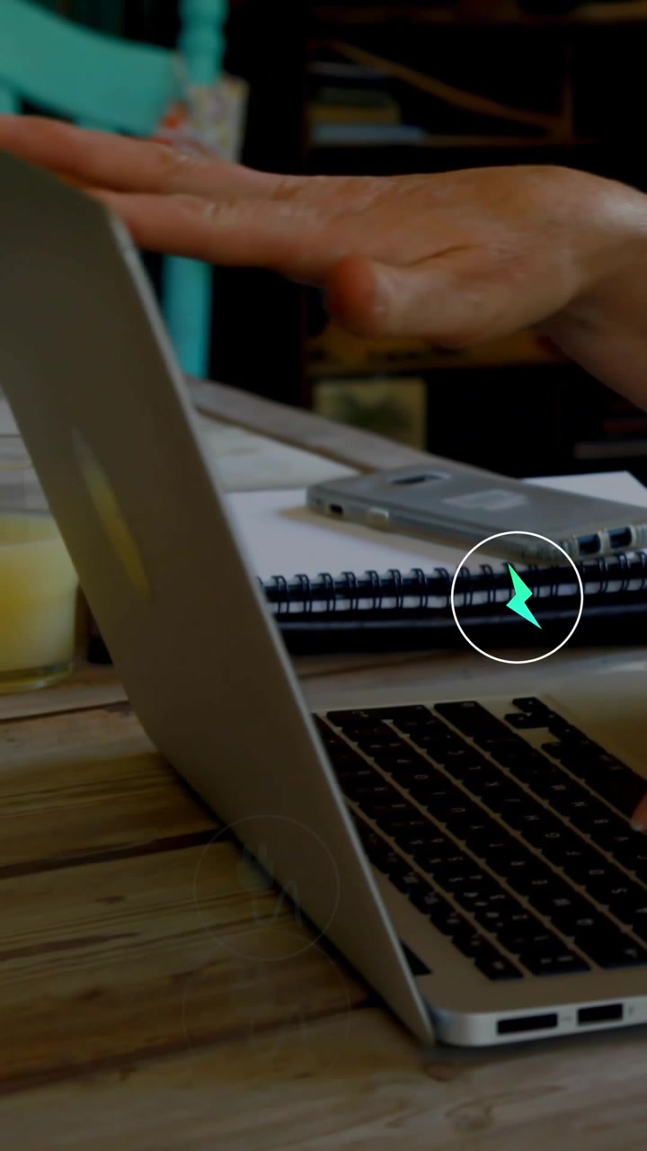 Video verticale: Donna che digita al portatile, una mano che inserisce una spina in una presa, mostrando energia per il lavoro.
