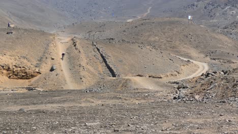 ciclistas de montaña que van cuesta abajo en colinas de tierra
