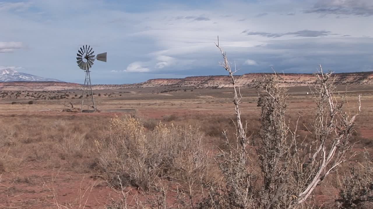 사막 평원에 서 있는 오래된 풍차의 긴 샷