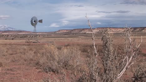 long shot of an old windmill standing out in a desert plain