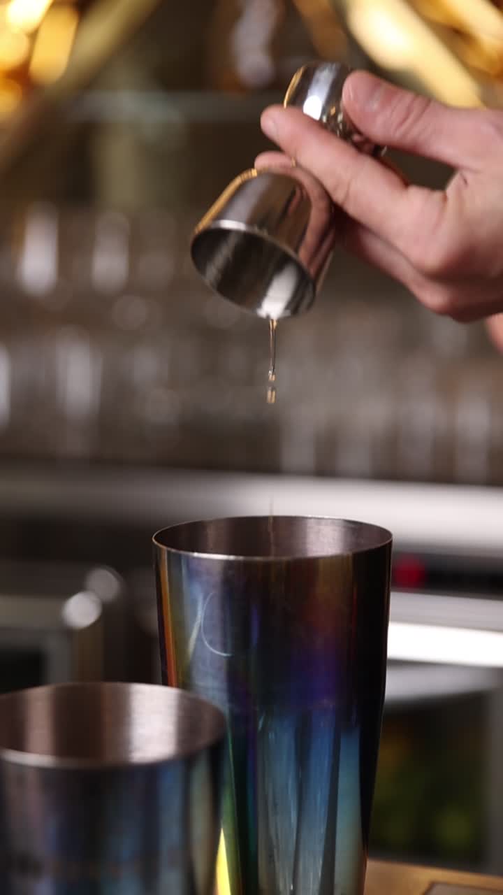 Mano che Versa Liquido da Jigger nello Shaker da Cocktail