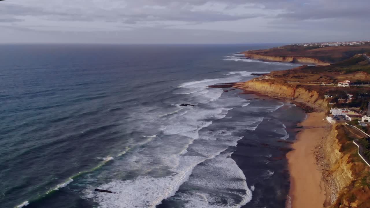 Drone shot paralleling towards land from the sea in Ericeira, Portugal