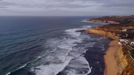 Disparo-De-Un-Dron-En-Paralelo-Hacia-La-Tierra-Desde-El-Mar-En-Ericeira,-Portugal