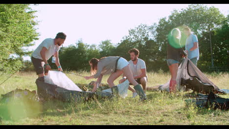 Group-Of-Young-Friends-Pitching-Tents-On-Camping-Holiday