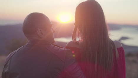 una pareja disfrutando de una vista del atardecer desde la cima de una montaña