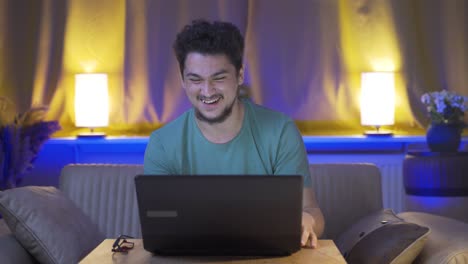 Laughing-man-using-laptop-at-night.