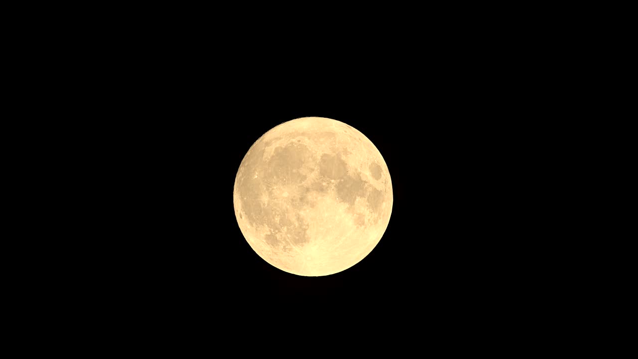 Lua Cheia no céu noturno escuro de setembro. A lua está se movendo da esquerda para a direita.