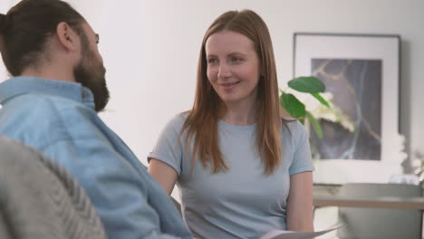 Bearded-Man-And-Beautiful-Woman-Have-A-Relaxed-Conversation-Sitting-On-The-Sofa-2