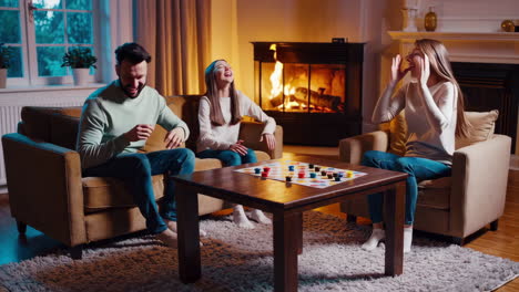 family playing a board game by the fireplace
