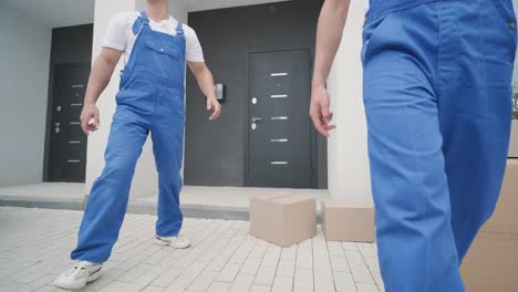 two young workers of removal company deliver boxes to a customer's home