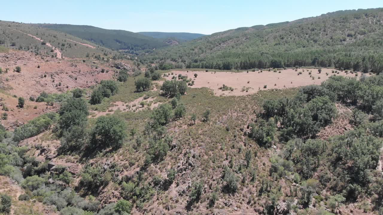 vista aérea de cerros en una zona rural, con el curso de un río y abundante vegetación