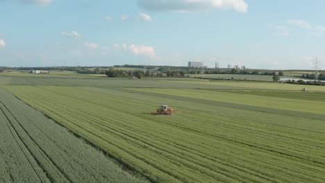 drone - aerial shot of a tractor spraying toxin - roundup on a corn field on a sunny day, 30p