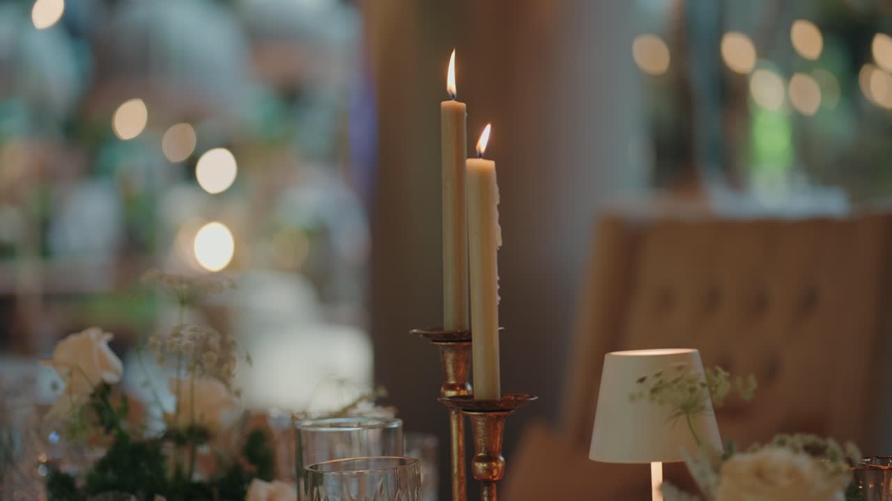 Elegante mesa de boda decorada con flores, velas y copas de cristal.