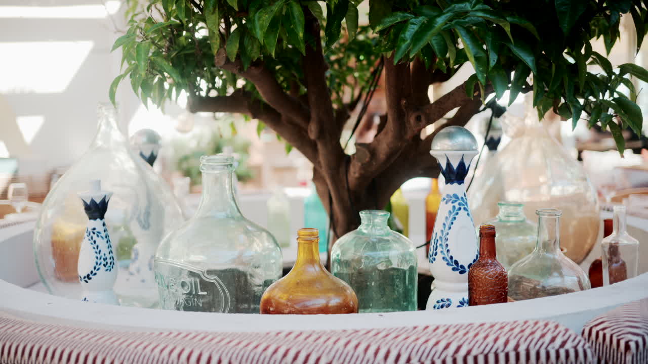 Wooden restaurant table prepared with glasses, plates, and napkins in warm natural light