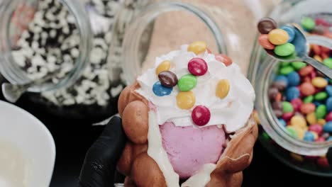 pouring rainbow candies on a waffle in a pastry shop