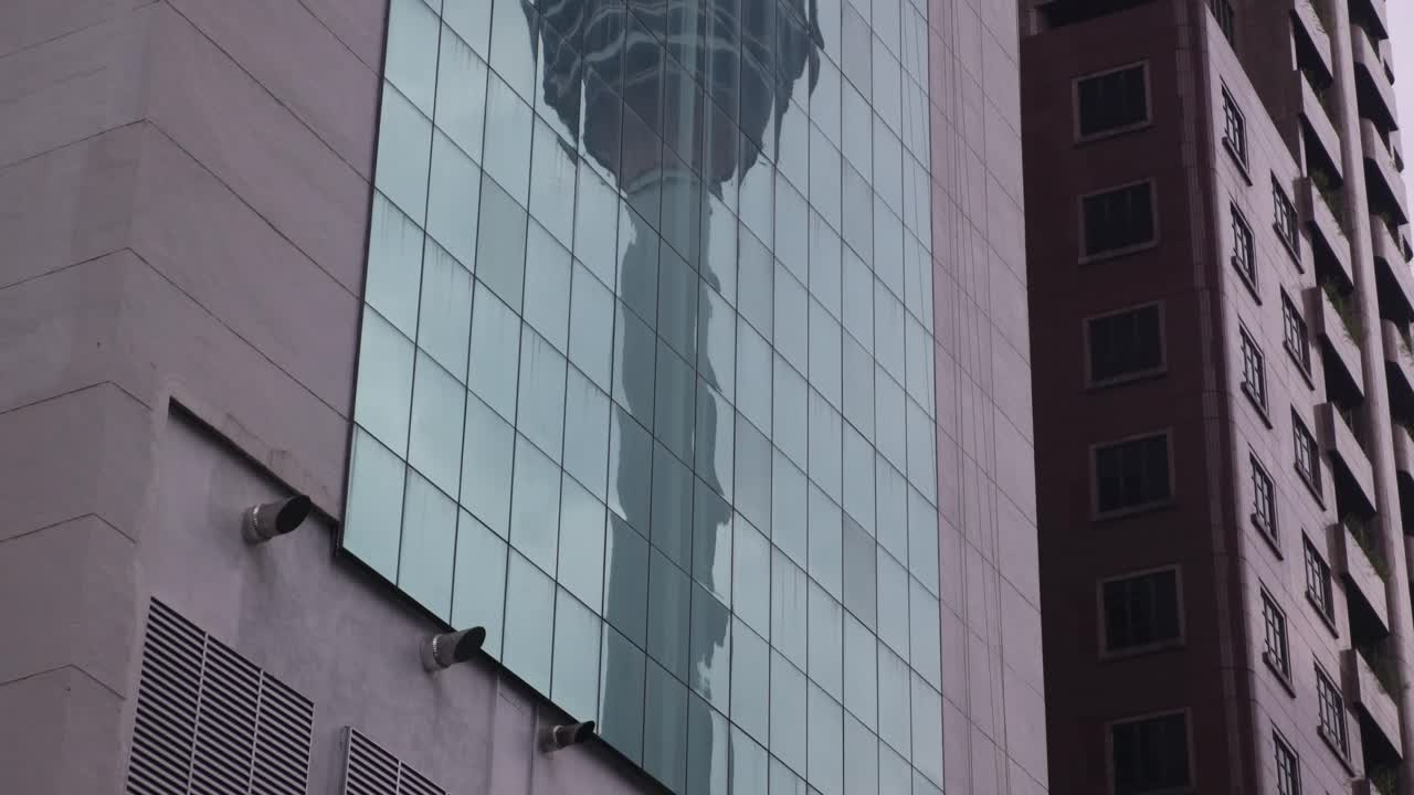 reflexión de la torre kl en las ventanas de un edificio de oficinas en kuala lumpur, malasia