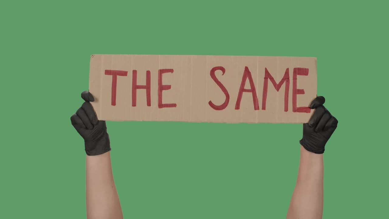 녹색 스크린, 크로마 키, 검은 장갑을 입은 손이 카드보드 상자에서 포스터를 들고, 평화적인 시위, 클로즈업, 느린 모션.