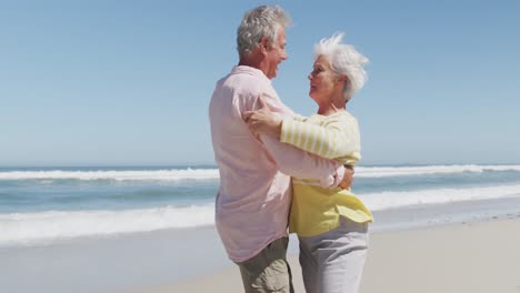 Feliz-Pareja-Caucásica-Senior-Hablando-Entre-Sí-Mientras-Bailan-En-La-Playa