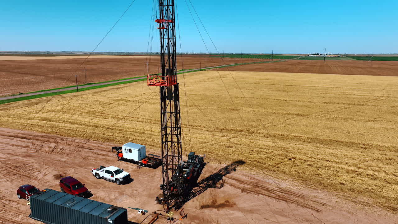 Circling around the truck with a risen rig for drilling oil. Little site for production natural resources in the dessert. Aerial view.