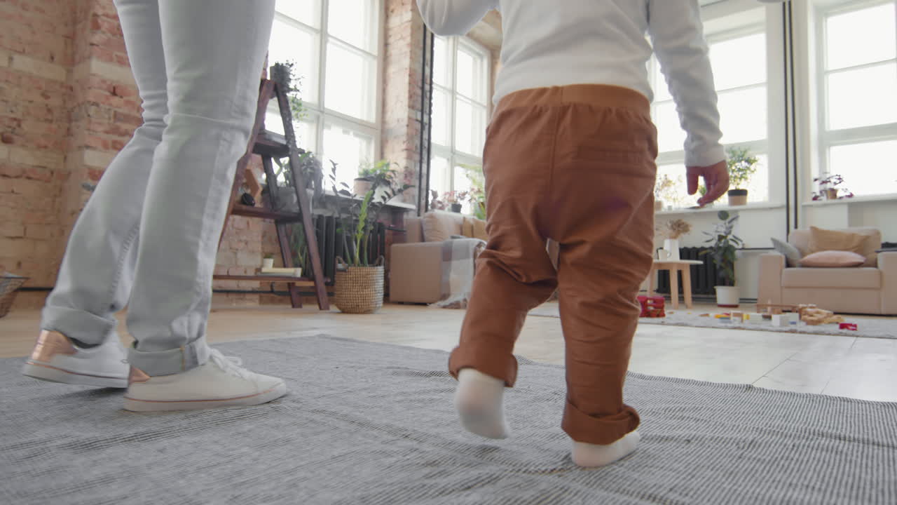 Low-Section of Mother and Toddler Walking at Home