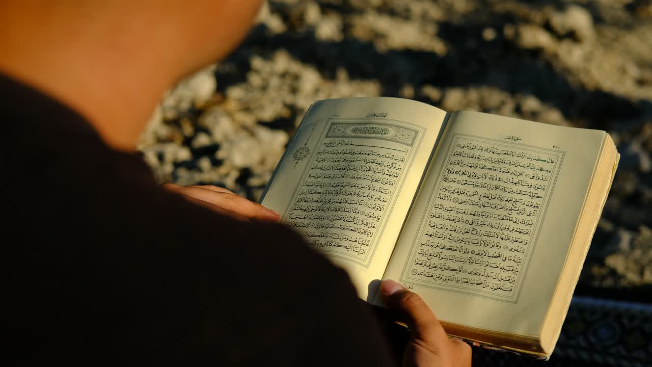 hombre leyendo el corán al aire libre