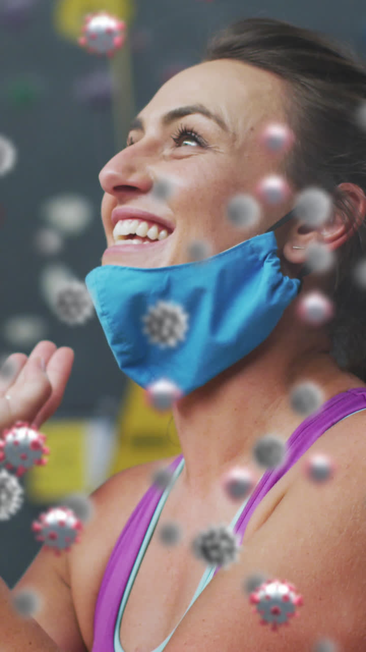 múltiples células de covid-19 flotando contra la mujer en forma caucásica hablando en teléfono inteligente en el gimnasio